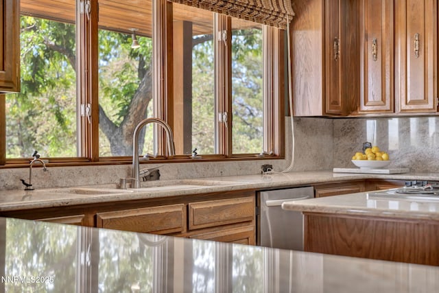 1405 Primrose Ln, Minden, NV 89423 - kitchen featuring backsplash, stainless steel dishwasher, light stone counters, and stovetop
