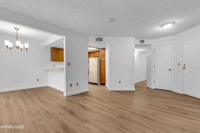 2875 Idlewild Dr Apt 5, Reno, NV 89509 - unfurnished living room featuring a textured ceiling, light wood-style floors, and a chandelier