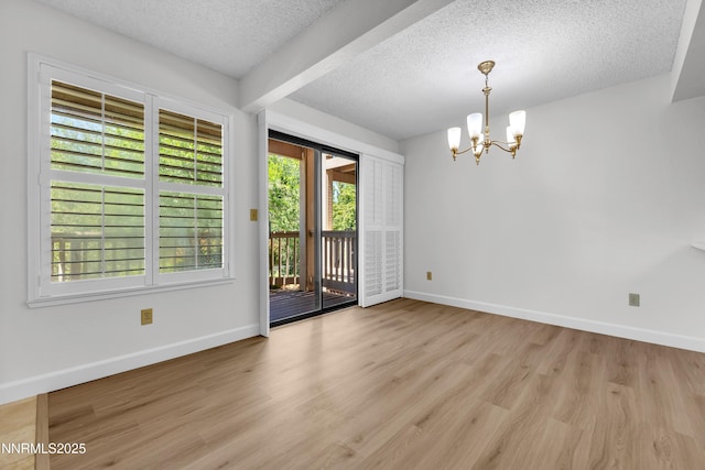 2875 Idlewild Dr Apt 5, Reno, NV 89509 - empty room featuring a chandelier, a textured ceiling, and wood finished floors