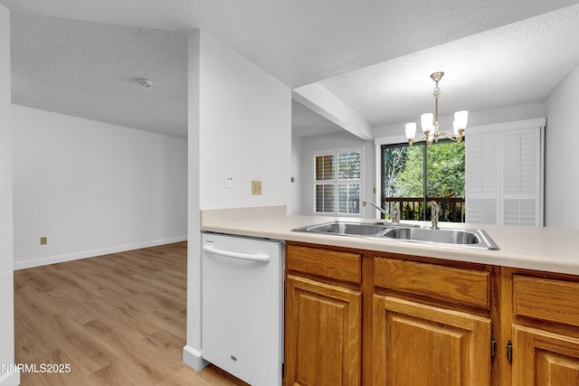 2875 Idlewild Dr Apt 5, Reno, NV 89509 - kitchen with white dishwasher, a chandelier, light wood-type flooring, a textured ceiling, and light countertops