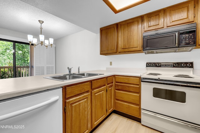 2875 Idlewild Dr Apt 5, Reno, NV 89509 - kitchen with white appliances, light countertops, a chandelier, light wood finished floors, and hanging light fixtures