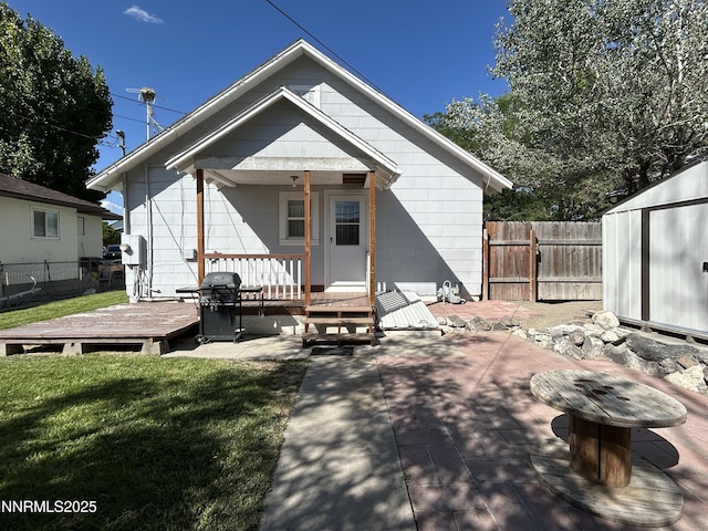 540 Garrison St, Winnemucca, NV 89445 - rear view of house featuring a fenced backyard, a deck, and a storage unit