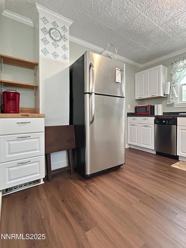 540 Garrison St, Winnemucca, NV 89445 - kitchen with appliances with stainless steel finishes, ornamental molding, dark wood-type flooring, and white cabinets