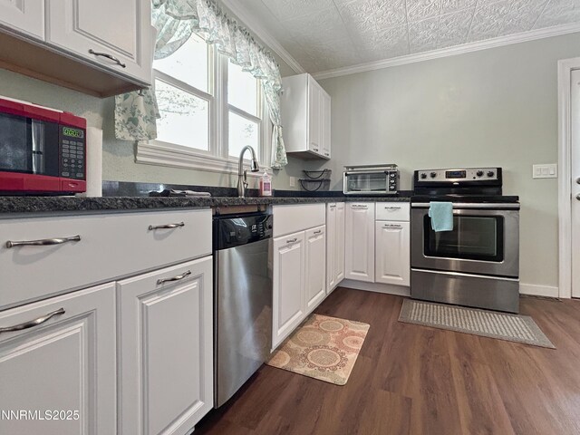540 Garrison St, Winnemucca, NV 89445 - kitchen with appliances with stainless steel finishes, dark wood-style flooring, white cabinets, an ornate ceiling, and ornamental molding