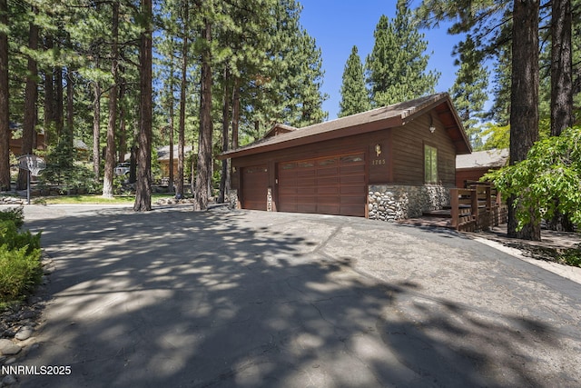 1705 Blue Spruce Rd, Reno, NV 89511 - view of home's exterior with stone siding, asphalt driveway, an outdoor structure, and an attached garage
