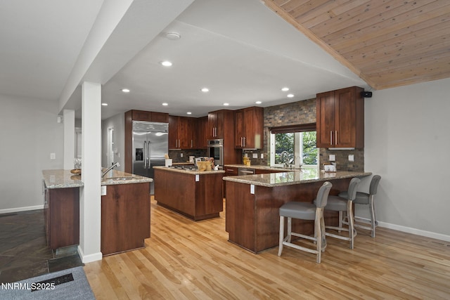 1705 Blue Spruce Rd, Reno, NV 89511 - kitchen with appliances with stainless steel finishes, decorative backsplash, recessed lighting, a peninsula, and light wood finished floors