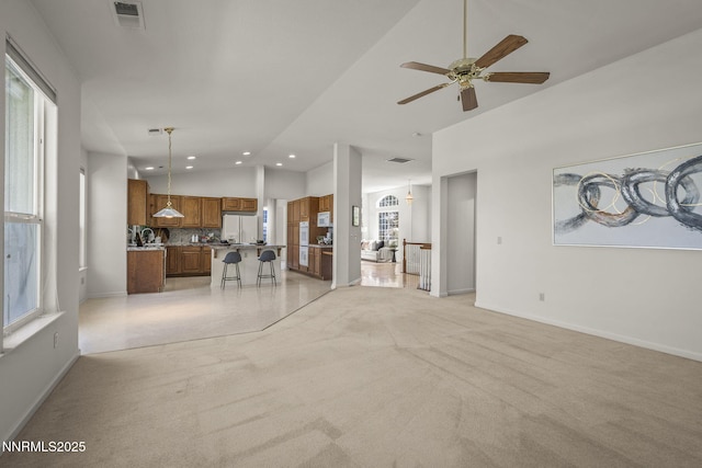 4811 Elkcreek Trl, Reno, NV 89519 - living area with vaulted ceiling, light colored carpet, a ceiling fan, recessed lighting, and plenty of natural light