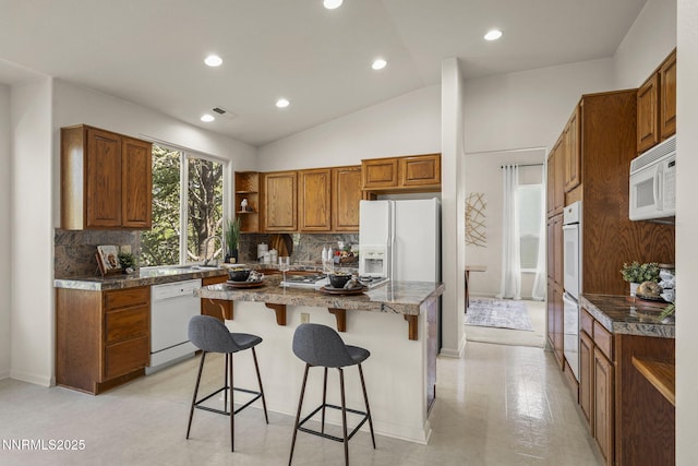 4811 Elkcreek Trl, Reno, NV 89519 - kitchen with white appliances, brown cabinets, open shelves, a breakfast bar, and recessed lighting