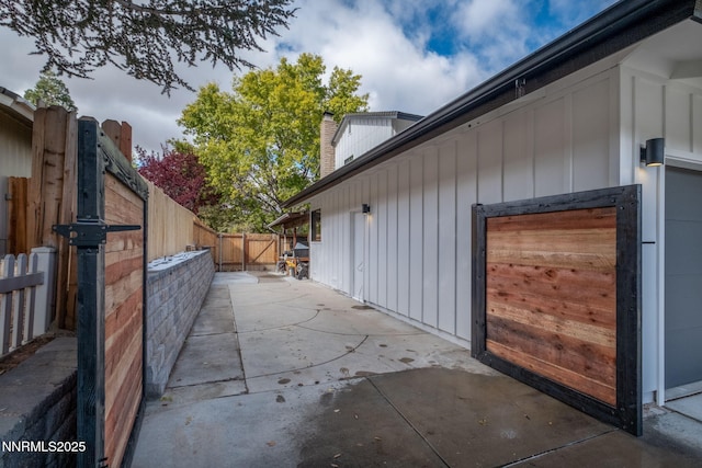 3390 Thornhill Dr, Reno, NV 89509 - view of property exterior featuring board and batten siding, a fenced backyard, a patio, and a chimney