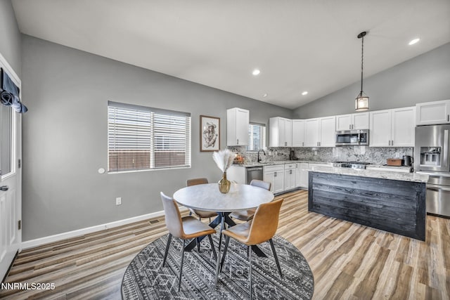 776 Great Basin Ln, Fallon, NV 89406 - dining room featuring vaulted ceiling, light wood-type flooring, and recessed lighting