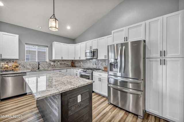 776 Great Basin Ln, Fallon, NV 89406 - kitchen featuring appliances with stainless steel finishes, lofted ceiling, decorative backsplash, light wood-type flooring, and white cabinetry