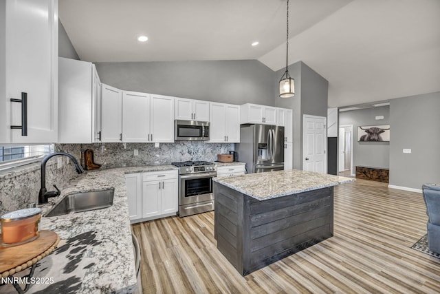 776 Great Basin Ln, Fallon, NV 89406 - kitchen featuring stainless steel appliances, high vaulted ceiling, white cabinetry, light stone countertops, and tasteful backsplash