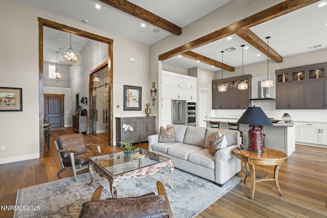 6122 S Pleasant Oak Trl, Reno, NV 89511 - living room with beamed ceiling, wood-type flooring, a chandelier, a barn door, and recessed lighting