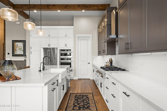 6122 S Pleasant Oak Trl, Reno, NV 89511 - kitchen featuring stainless steel appliances, wall chimney exhaust hood, beam ceiling, dark wood finished floors, and hanging light fixtures