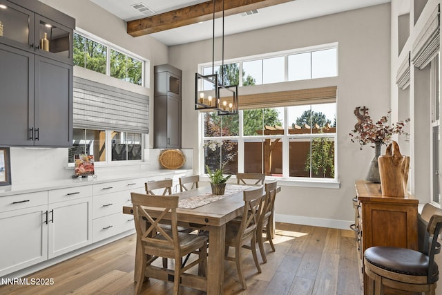 6122 S Pleasant Oak Trl, Reno, NV 89511 - dining space featuring a chandelier, beamed ceiling, light wood-style flooring, healthy amount of natural light, and a towering ceiling