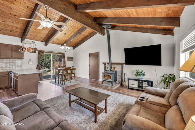 1419 Leonard Rd, Gardnerville, NV 89460 - living area featuring a wood ceiling with exposed beams, a wood stove, wood finished floors, ceiling fan, and a chandelier
