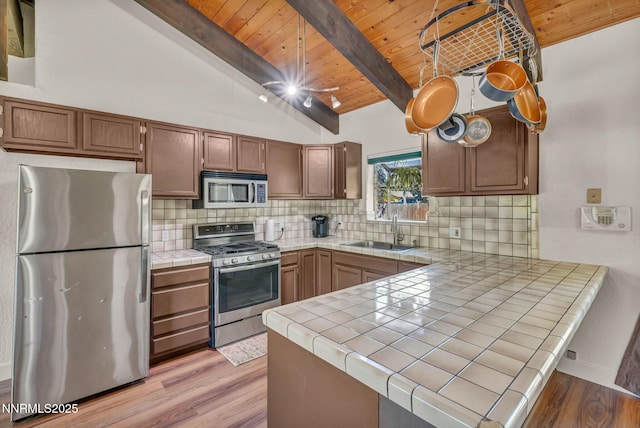 1419 Leonard Rd, Gardnerville, NV 89460 - kitchen featuring appliances with stainless steel finishes, tile counters, a peninsula, wooden ceiling, and light wood-type flooring