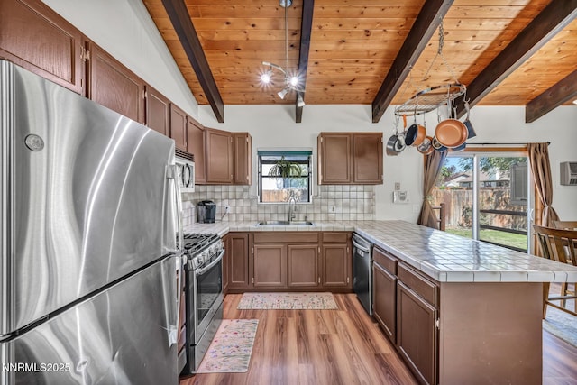 1419 Leonard Rd, Gardnerville, NV 89460 - kitchen featuring stainless steel appliances, a peninsula, tile counters, light wood-style flooring, and wooden ceiling