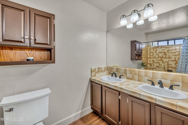 1419 Leonard Rd, Gardnerville, NV 89460 - full bathroom featuring double vanity, wood finished floors, decorative backsplash, a shower with curtain, and a textured wall
