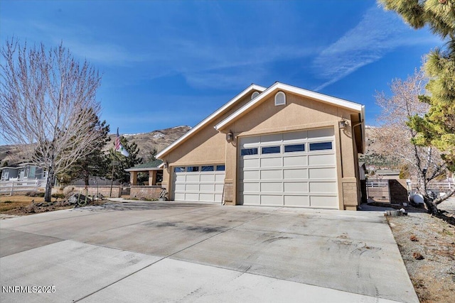 1962 Comstock Dr, Gardnerville, NV 89410 - view of front of home with stucco siding, driveway, a mountain view, and a garage