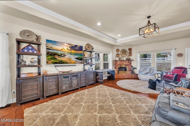 1962 Comstock Dr, Gardnerville, NV 89410 - living area featuring ornamental molding, a chandelier, wood finished floors, a fireplace with raised hearth, and a raised ceiling