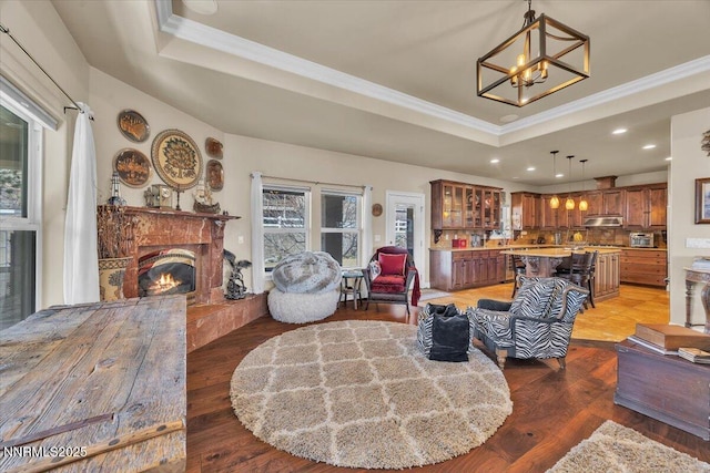 1962 Comstock Dr, Gardnerville, NV 89410 - living room with a tray ceiling, a chandelier, ornamental molding, a warm lit fireplace, and recessed lighting