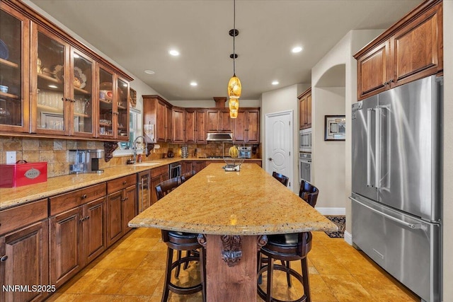 1962 Comstock Dr, Gardnerville, NV 89410 - kitchen with stainless steel appliances, decorative backsplash, recessed lighting, a breakfast bar, and light stone countertops