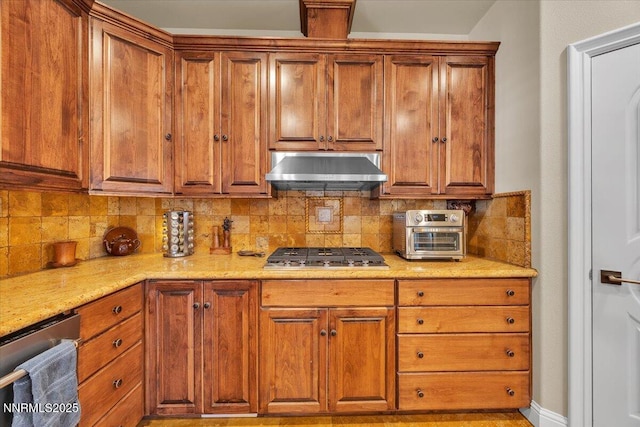 1962 Comstock Dr, Gardnerville, NV 89410 - kitchen with wall chimney exhaust hood, appliances with stainless steel finishes, decorative backsplash, brown cabinetry, and light stone counters