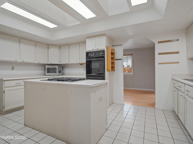 2843 Wade St, Minden, NV 89423 - kitchen with appliances with stainless steel finishes, light tile patterned floors, a kitchen island, light countertops, and white cabinets
