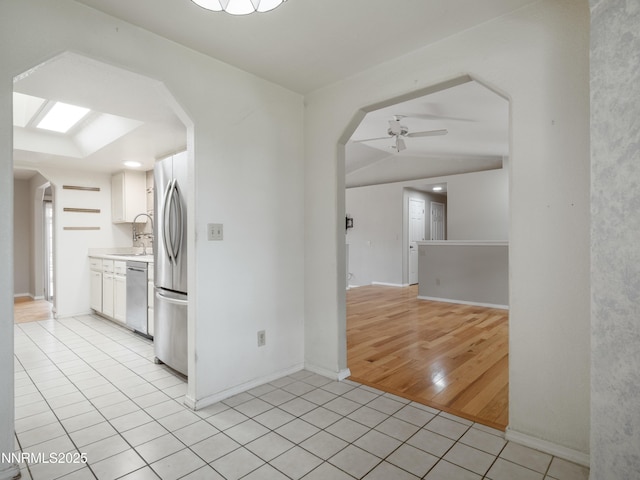 2843 Wade St, Minden, NV 89423 - kitchen with appliances with stainless steel finishes, light tile patterned flooring, arched walkways, ceiling fan, and light countertops