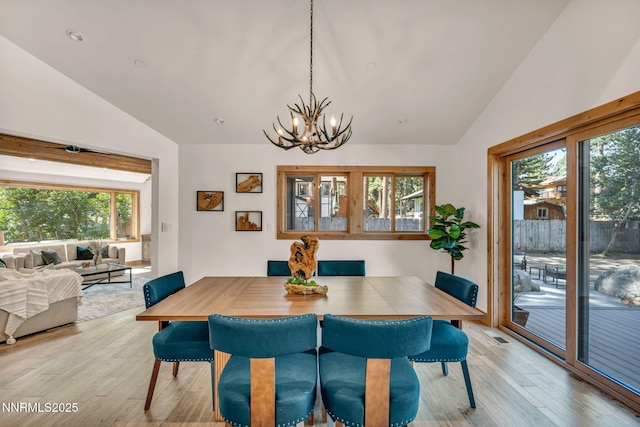 116 Cypress Way, Stateline, NV 89449 - dining area featuring lofted ceiling, plenty of natural light, light wood finished floors, and a chandelier