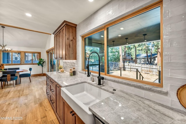 116 Cypress Way, Stateline, NV 89449 - kitchen featuring brown cabinetry, light stone counters, light wood finished floors, a chandelier, and recessed lighting