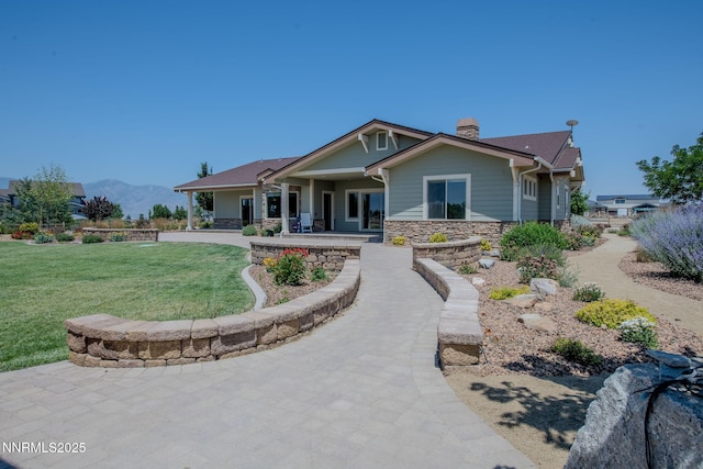 1725 Grandview Pkwy, Minden, NV 89423 - craftsman-style house featuring stone siding, a front lawn, a chimney, a mountain view, and covered porch