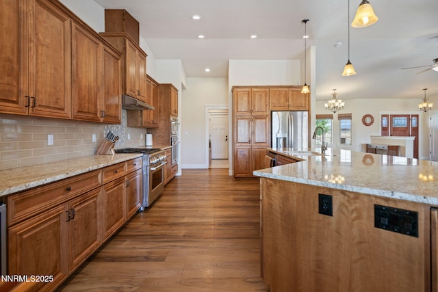 1725 Grandview Pkwy, Minden, NV 89423 - kitchen with a chandelier, stainless steel appliances, brown cabinets, dark wood-style flooring, and light stone countertops
