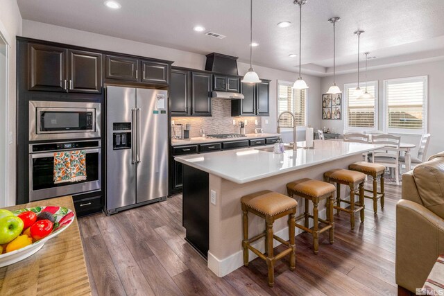 1230 W Cottage Loop, Gardnerville, NV 89460 - kitchen with stainless steel appliances, wood finished floors, light countertops, a kitchen bar, and recessed lighting
