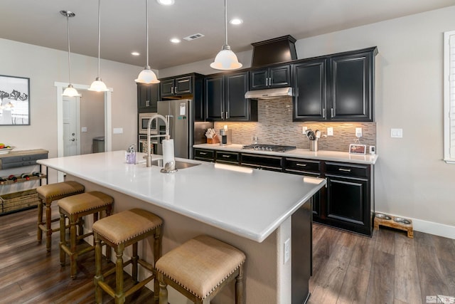 1230 W Cottage Loop, Gardnerville, NV 89460 - kitchen with dark wood-style floors, dark cabinets, a kitchen bar, tasteful backsplash, and recessed lighting