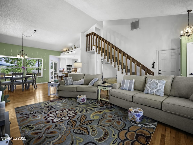 1755 Mizpah St, Winnemucca, NV 89445 - living room featuring a chandelier, stairs, wood finished floors, high vaulted ceiling, and a textured ceiling