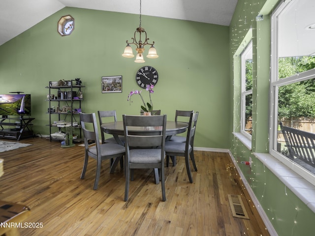 1755 Mizpah St, Winnemucca, NV 89445 - dining space with wood finished floors, a chandelier, and vaulted ceiling