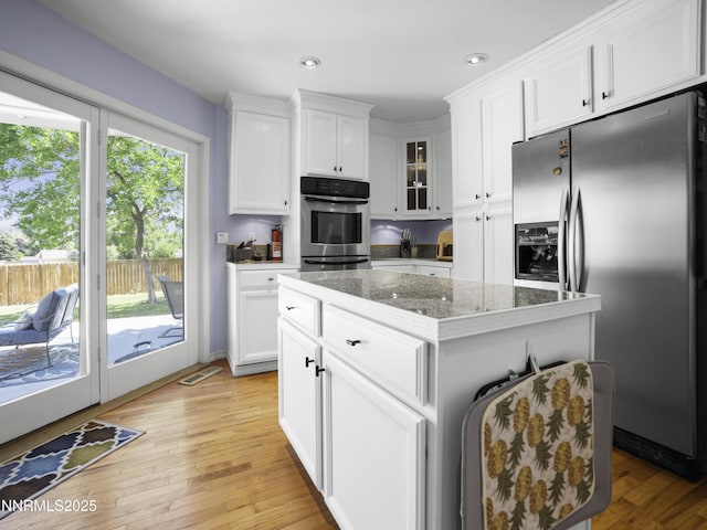 1755 Mizpah St, Winnemucca, NV 89445 - kitchen with stainless steel fridge with ice dispenser, light wood-style floors, white cabinets, glass insert cabinets, and a kitchen island