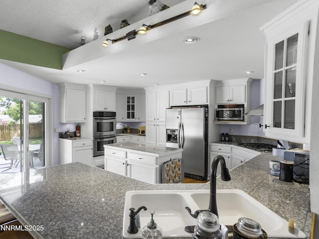 1755 Mizpah St, Winnemucca, NV 89445 - kitchen featuring stainless steel appliances, a kitchen island, white cabinets, glass insert cabinets, and recessed lighting