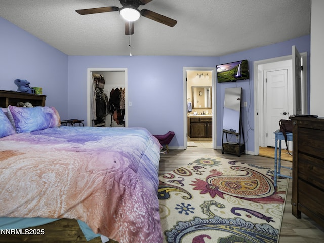 1755 Mizpah St, Winnemucca, NV 89445 - bedroom featuring a textured ceiling, a walk in closet, light wood finished floors, ensuite bath, and ceiling fan