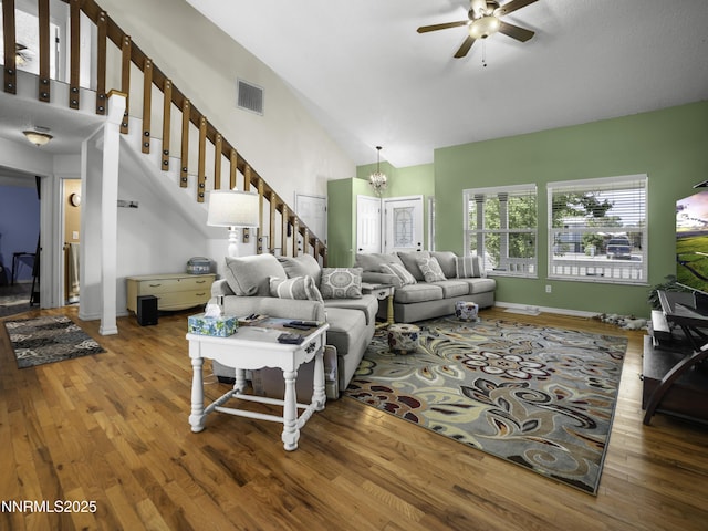1755 Mizpah St, Winnemucca, NV 89445 - living area featuring wood finished floors, stairs, a ceiling fan, a chandelier, and high vaulted ceiling