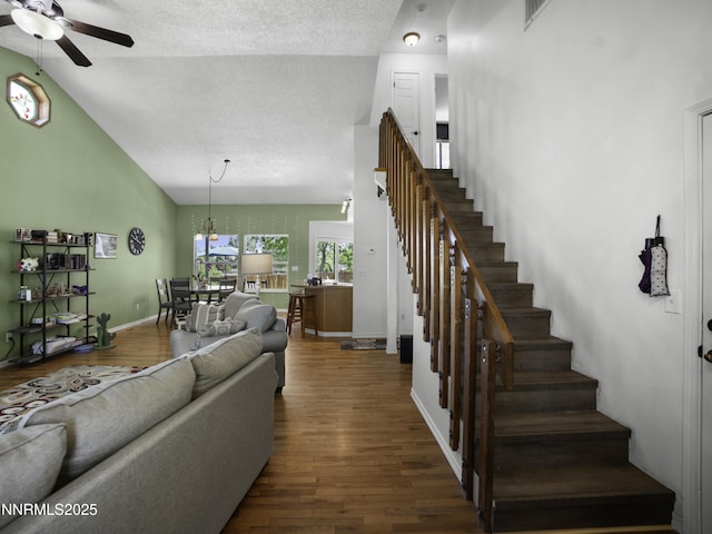1755 Mizpah St, Winnemucca, NV 89445 - living room featuring a ceiling fan, stairs, a textured ceiling, dark wood-type flooring, and high vaulted ceiling