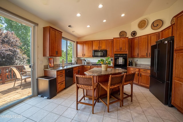 2691 Sutter Butte Ct, Sparks, NV 89436 - kitchen with black appliances, recessed lighting, light tile patterned floors, brown cabinetry, and lofted ceiling