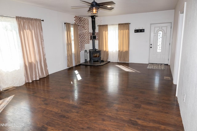 406 W 5th St, Winnemucca, NV 89445 - unfurnished living room featuring wood finished floors, a wood stove, and a ceiling fan