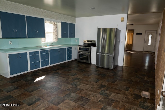 406 W 5th St, Winnemucca, NV 89445 - kitchen with blue cabinetry, stainless steel appliances, and light countertops
