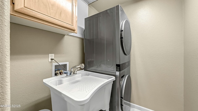 7302 Little Easy St, Sparks, NV 89436 - laundry room featuring cabinet space, stacked washer / dryer, and a textured wall