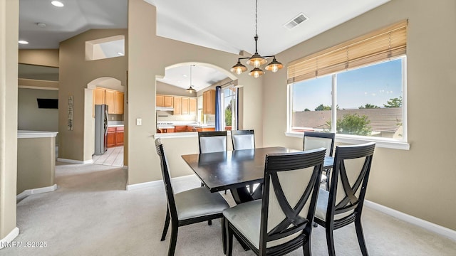 7302 Little Easy St, Sparks, NV 89436 - dining area featuring arched walkways, vaulted ceiling, light colored carpet, a chandelier, and recessed lighting