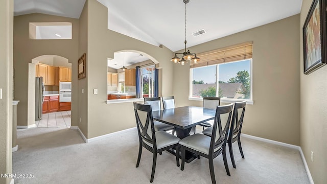 7302 Little Easy St, Sparks, NV 89436 - dining room with arched walkways, a chandelier, vaulted ceiling, and light colored carpet