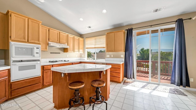 7302 Little Easy St, Sparks, NV 89436 - kitchen with tile countertops, white appliances, vaulted ceiling, a kitchen island, and recessed lighting